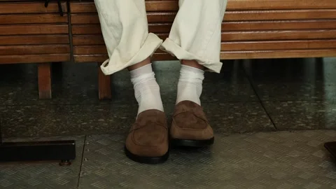Stylish loafers complement relaxed spring outfit at a transit station Vídeo Stock 310955077