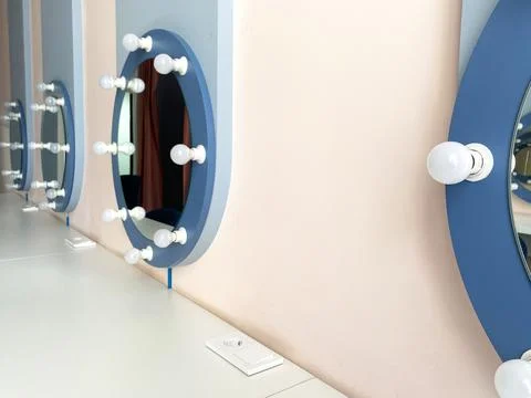 Stylish makeup vanity with circular mirrors and bright bulbs, showcasing a Фото
