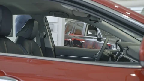Stylish man with a beard is choosing new automobile walking around luxury car Stock Footage 101111533