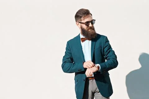 Stylish man with beard wearing a jacket, shirt and bow tie Stock Photos
