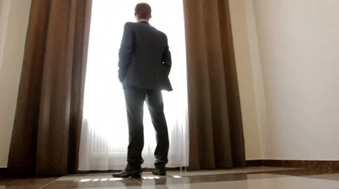 Stylish man in black suit looking out the window Stock Footage 37674949