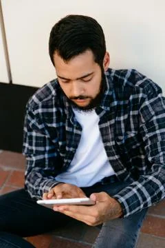 Stylish man browsing websites while using his tablet, outdoors Stock Photos