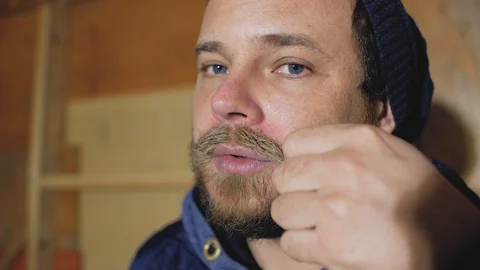 Stylish man in a cap straightens his mustache Stock Footage 102768273