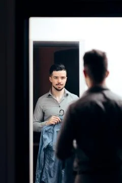 Stylish Man Checking Himself in the Mirror Trying on Clothes Stock Photos