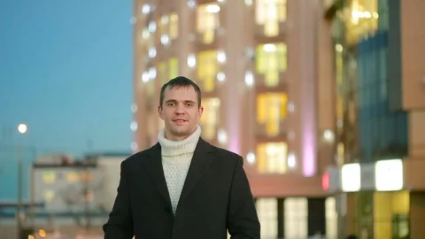 Stylish man in a coat walking in modern city on the background of skyscrapers Stock Footage 71904922