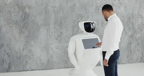 A stylish man communicates with a robot, presses a plastic mechanical arm to the Stock Footage 97967574