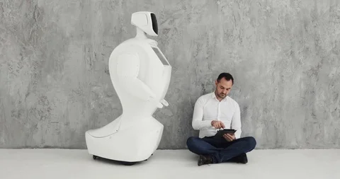 A stylish man communicates with a robot, presses a plastic mechanical arm to the Vídeo Stock 97967673
