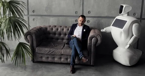 A stylish man communicates with a robot, presses a plastic mechanical arm to the Stock Footage 97967782