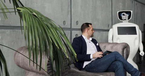 A stylish man communicates with a robot, presses a plastic mechanical arm to the Stock Footage 97967828