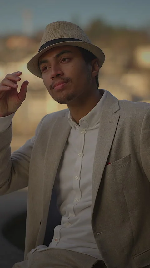 A Stylish Man Dressed in a Beige Suit Complemented with a Hat at Sunset by Vídeos de archivo 288263293