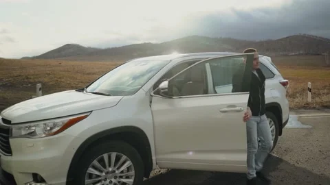 Stylish man getting out of white car. Business man with mobile get out from auto Stock Footage 157218209