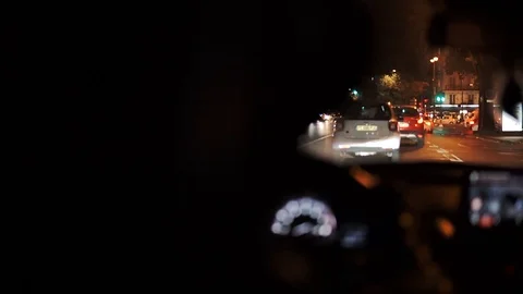 Stylish Man in hat driving a Car in Paris at Night, with brurred night street Stock Footage 119704769