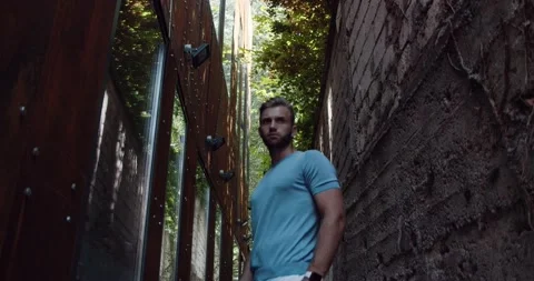 A stylish man, laying on the wall while he is looking on his watch Stock Footage 142308274