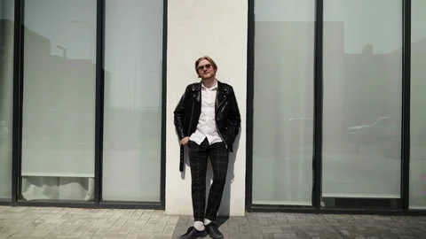A stylish man in a leather jacket stands near the counter of a store. Sunny mood Stock Footage 247130210