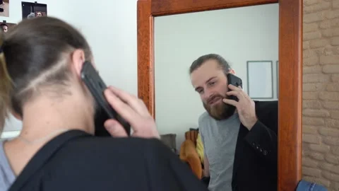Stylish man  looking at himself into a mirror Talking on smartphone Stock Footage 147894641