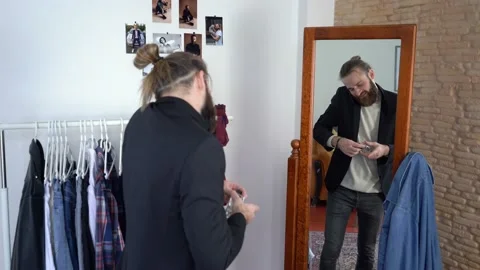 Stylish man looking in a mirror /  Talking on the smartphone / Spraying Parfume Stock Footage 147893029