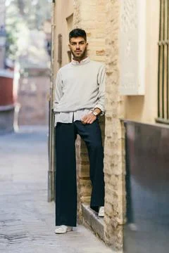Stylish man posing while looking at the camera with a cocky expression outdoors Stock Photos