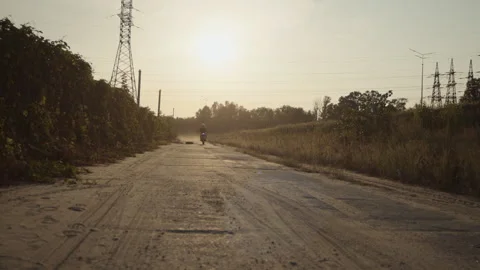 Stylish man is riding  on motorcycle in sunlight on the off-road Stock Footage 253448208