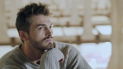 Stylish man sits in pose on the rafter of old building. Slowly Video stock 80922455