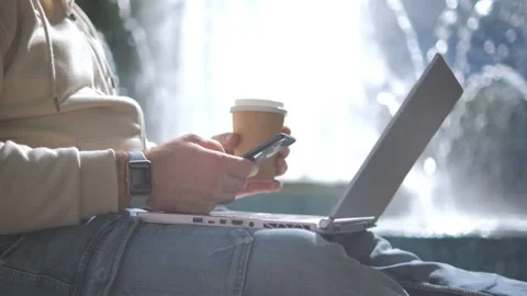 Stylish man sitting under park tree with laptop. Relaxed man using wireless Видео 254698443