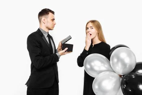 Stylish man in a suit makes a proposal for marriage to a girl who is shocked, Stock Photos