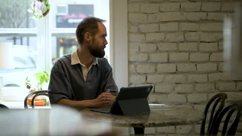 Stylish man talking at a table in a cafe Stock Footage 308636538