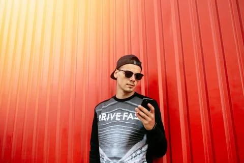 Stylish man using a cell phone, standing outdoors Stock Photos
