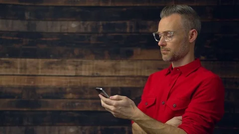 Stylish man using handheld device gets serious Stock Footage 85437844