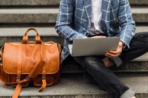 Stylish man using laptop computer on a street. Freelance work concept Stockfoto's