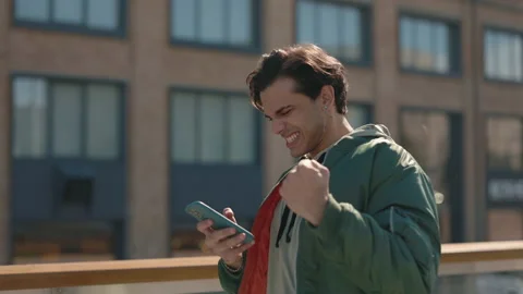 Stylish man using mobile and gesturing from happiness 動画素材 164034981