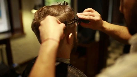 A stylish men cut his beard and hair in the barbershop Stock Footage 73871647
