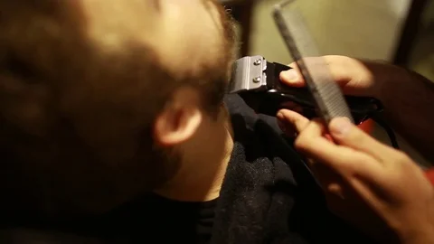 A stylish men cut his beard and hair in the barbershop Stock Footage 73871665