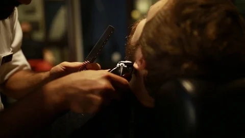 A stylish men cut his beard and hair in the barbershop Stock Footage 73871667
