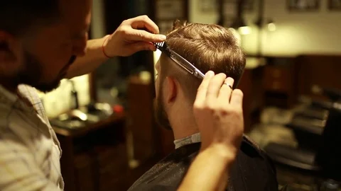 A stylish men cut his beard and hair in the barbershop Stock Footage 73871673