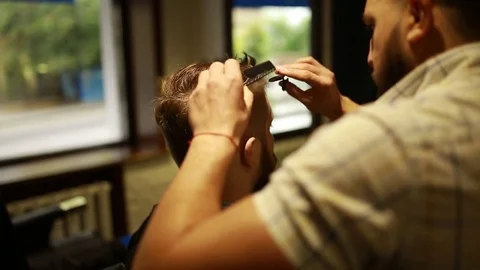 A stylish men cut his beard and hair in the barbershop Stock Footage 73871677
