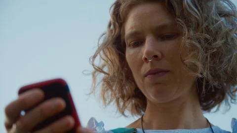 Stylish middle-aged woman using her phone while outside in a park Stock Footage 120540622