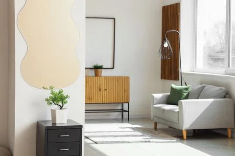 Stylish mirror hanging on light wall in room Stock Photos