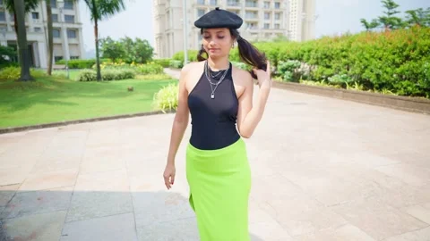 Stylish model fixes her lipstick before garden photoshoot Stock Footage 310286359