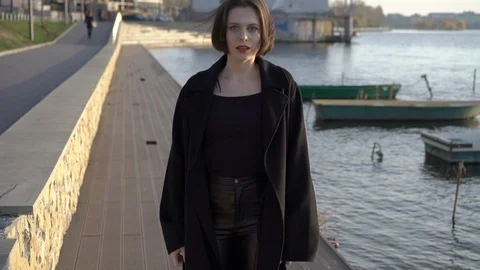 Stylish model flirts to camera, turns and walks away at the lake Video stock 124731981