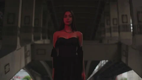 Stylish Model looking at camera in orange light under iron bridge Stock Footage 159540875