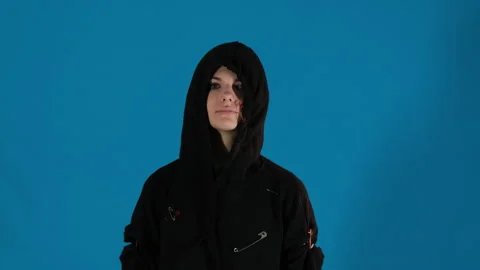 Stylish model tightens elastic bands of hood covering face Stock Footage 306501174