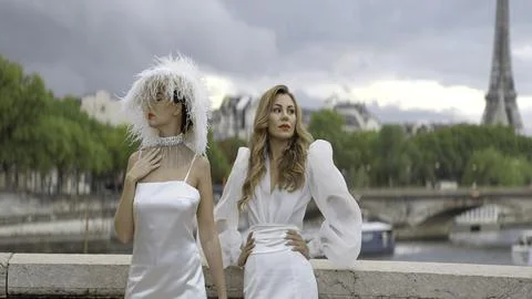 Stylish models in white dresses posing on the background of Paris streets and Stock Photos