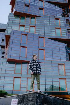 Stylish modern guy against the backdrop of an office glass building, young ma Stock Photos