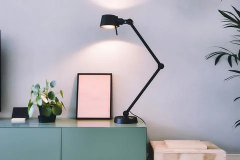 Stylish modern interior, empty picture frame with black lamp and green Chinese Stock Photos
