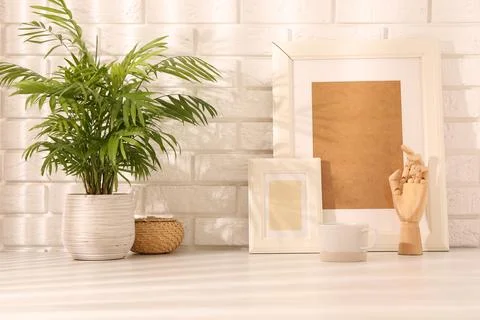 Stylish office workplace. Decor elements, plant and cup on white table near.. Stock Photos