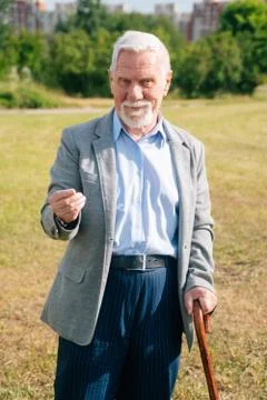 Stylish old man asks to give money. Portrait of long old merry European grand Stock Photos