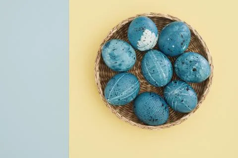 Stylish painted easter eggs on two-color yellow-blue background with copy space Stock Photos