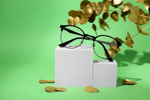 Stylish presentation of glasses on green background. Space for text Stock Photos
