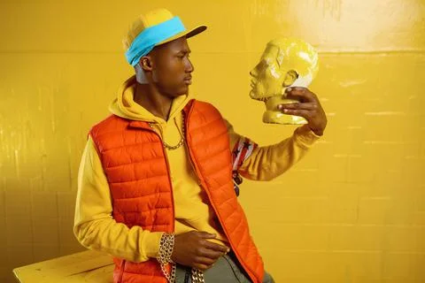Stylish rapper poses in studio with yellow tones Stock Photos