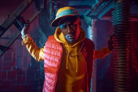 Stylish rapper in yellow hoodie posing in studio Stock Photos